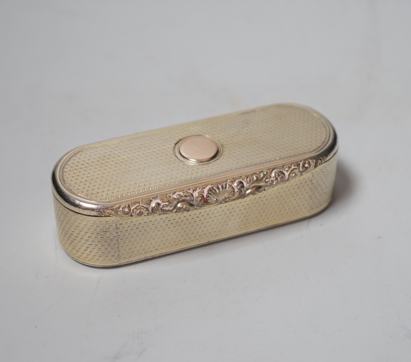 A George IV engine turned silver gilt oval snuff box, with interior Latin inscription, John Linnit, London, 1828, 9cm.